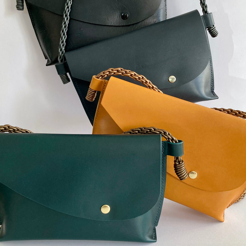 Mini sacs Oyat en cuir safran, vert sapin, bleu nuit et noir, avec leurs lanières tressées