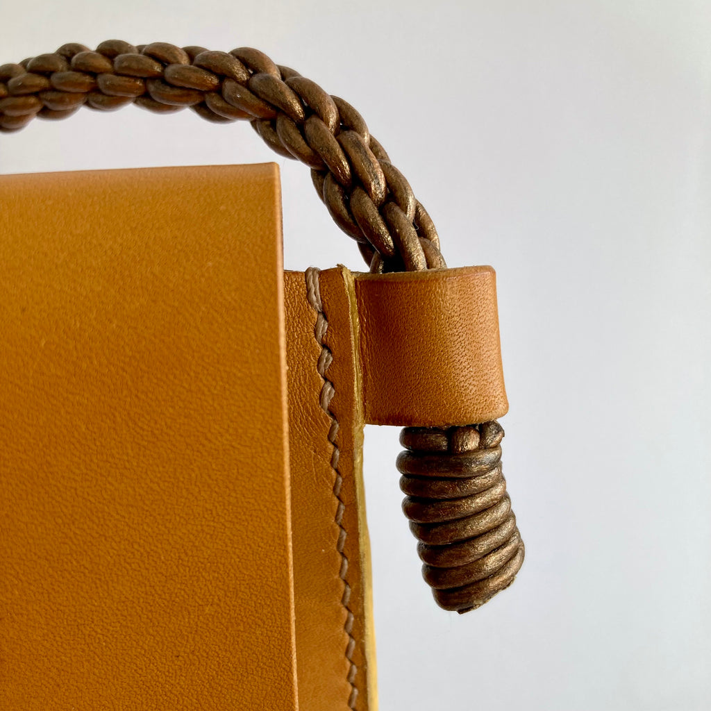 Mini sac Oyat safran, détail de la couture main et de la lanière cuivre